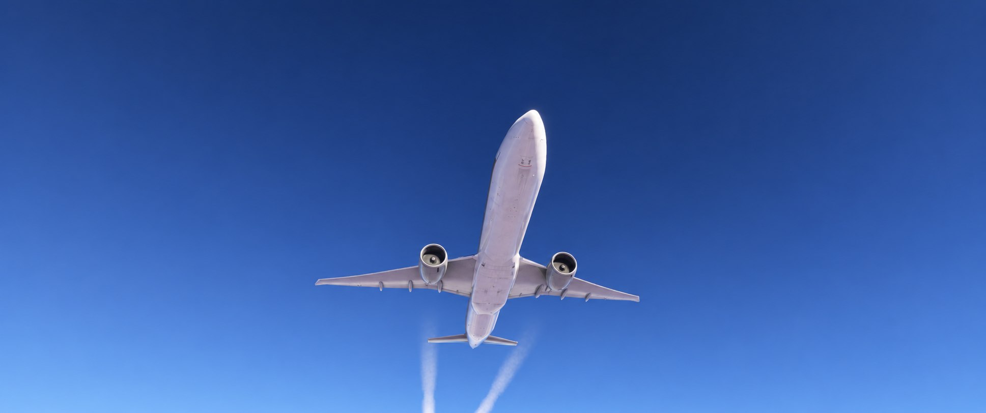 An airliner seen from below against a blue sky
